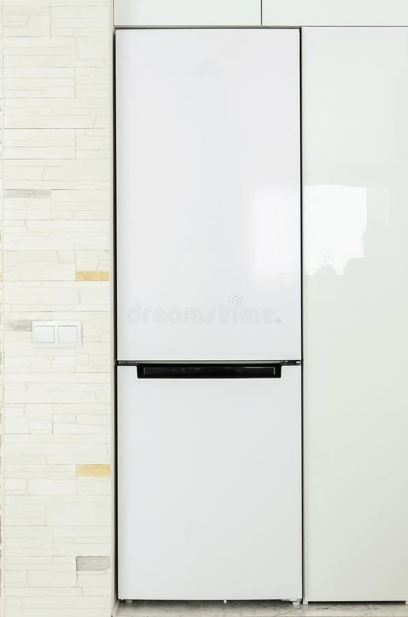 White Refrigerator Built into the Kitchen Unit. Closeup, Vertical Photography Stock Image