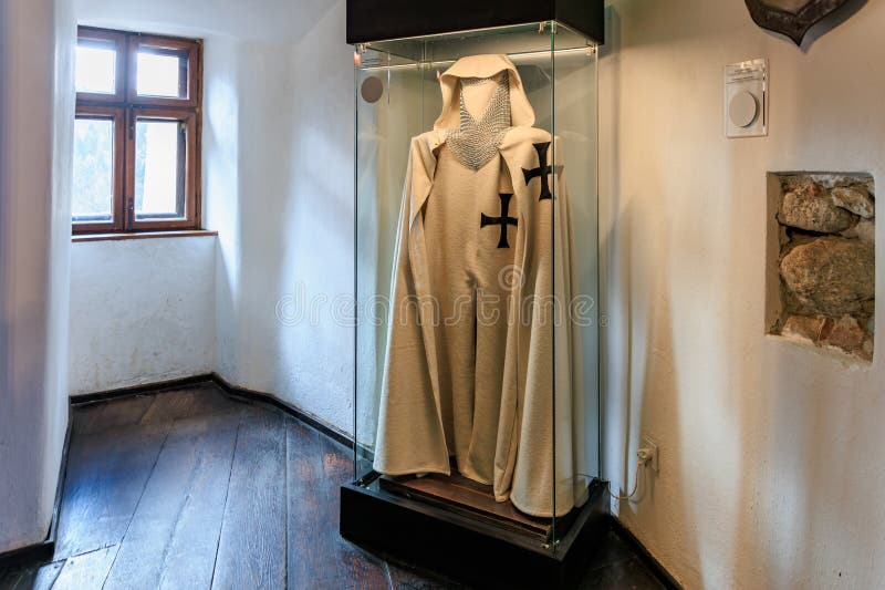 White robe with a cross on it is displayed in a glass case, castle of Dracula. December 16, 2024 Bran Romania royalty free stock photos