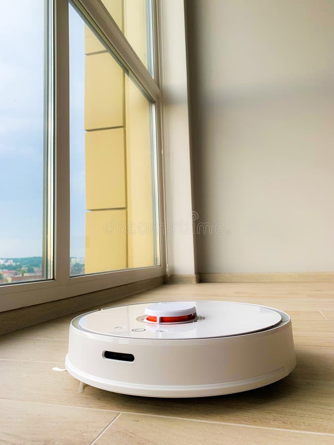White Robot Cleaner. Robot Vacuum Cleaner on Laminate Floor in Action