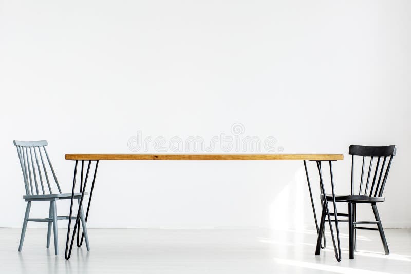 White room with two chairs at a long wooden table, real photo with copy space stock photos