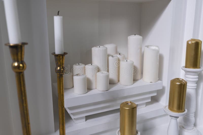 White Round Wax Candles of Different Sizes on a White Shelf Stock Image