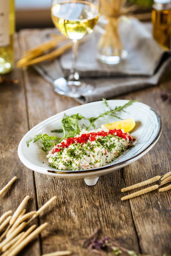 White salad with red caviar tobiko and green onion. Closeup on white salad decorated with red caviar of flying fish tobiko and green onion, vertical royalty free stock image White salad with red caviar tobiko and green onion. Closeup on white salad decorated with red caviar of flying fish tobiko and green onion, vertical royalty free stock image