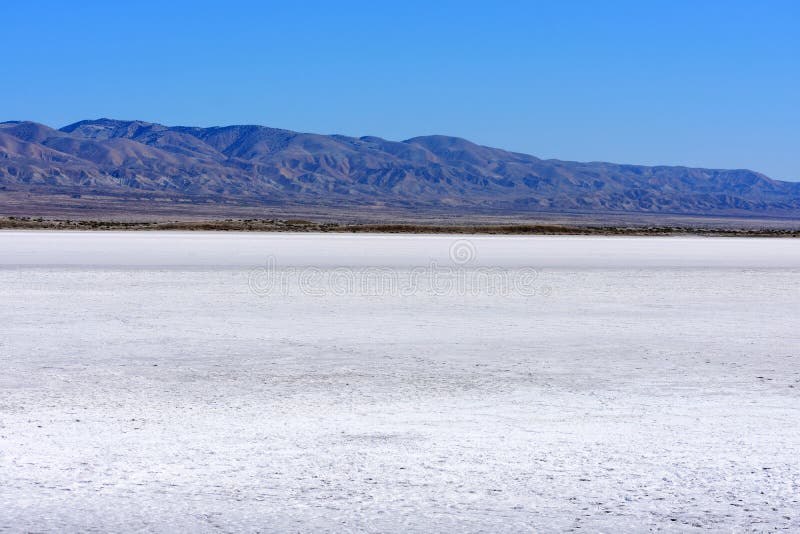 White salt flats of dry Soda Lake at Carrizo Plain National Monument. Temblor Range mountains on horizon on hot and sunny day