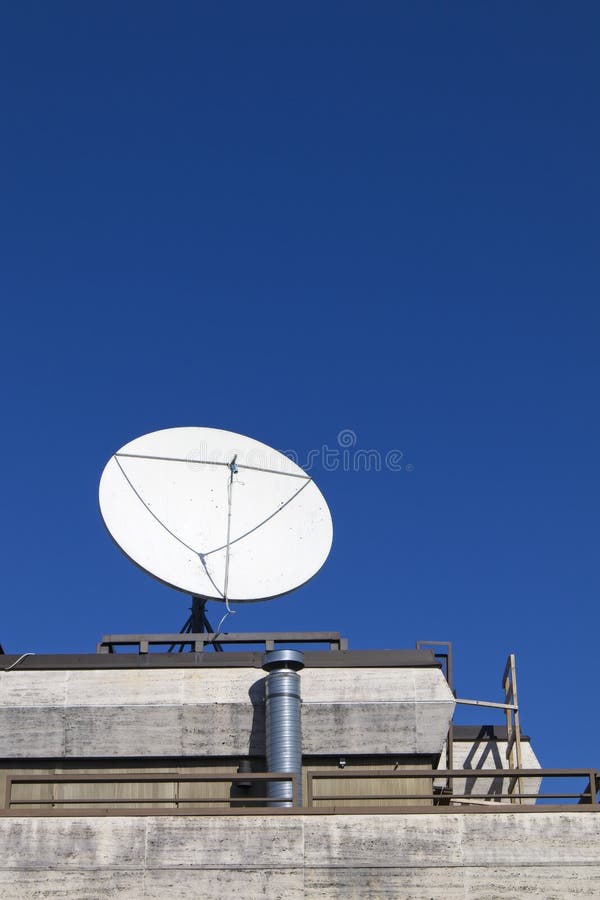 White Satellite Dish Antenna on the Roof Against Blue Sky Stock Photo