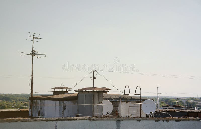 White satellite dishes with two converters mounted on residental building rooftop concrete wall. Satellite television advertisement