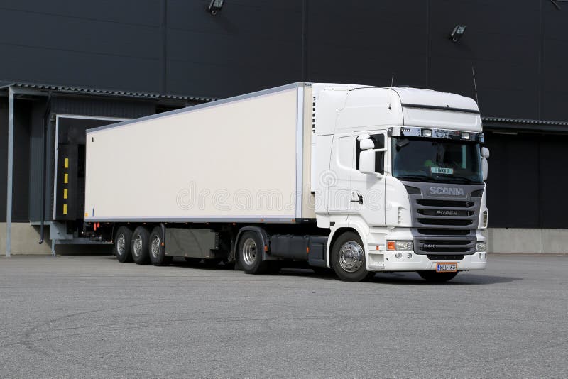 White Scania Semi Truck Unloading at Warehouse Building