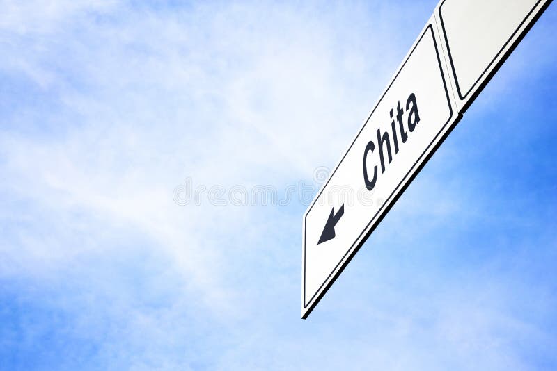 White signboard with an arrow pointing left towards Chita, Zabaykalsky Krai, Russia, against a hazy blue sky in a concept of travel, navigation and direction. Path included. White signboard with an arrow pointing left towards Chita, Zabaykalsky Krai, Russia, against a hazy blue sky in a concept of travel, navigation and direction. Path included