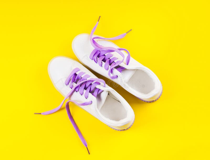 White Sneakers with Purple Laces on Yellow Background Stock Photo ...