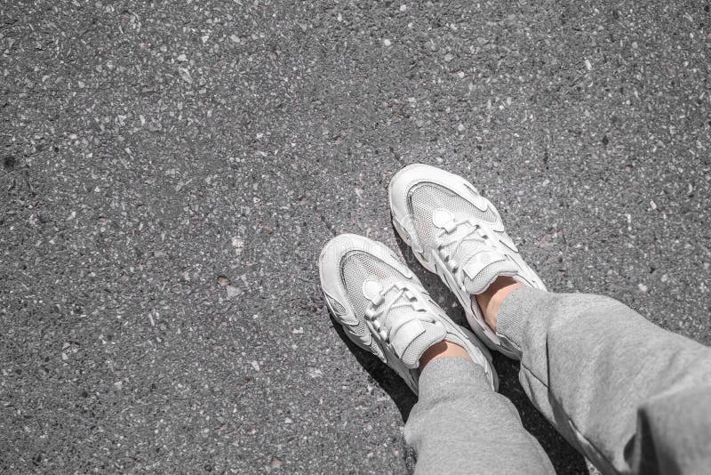 White Sneakers Walking on Concrete. Sneakers on the Pavement. Top View ...