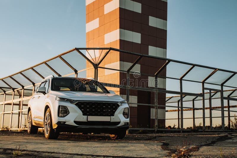 White compact SUV car with sport and modern design parked on concrete road by the sea near the beach at sunset royalty free stock image White compact SUV car with sport and modern design parked on concrete road by the sea near the beach at sunset royalty free stock image