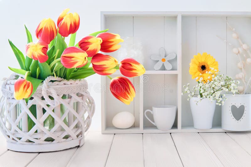 White table with red and yellow tulips and springtime decorations stock images