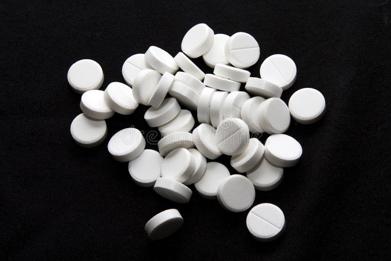 White tablets on a black background