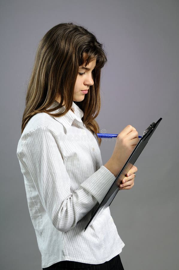 White teenager writing on paper with pen