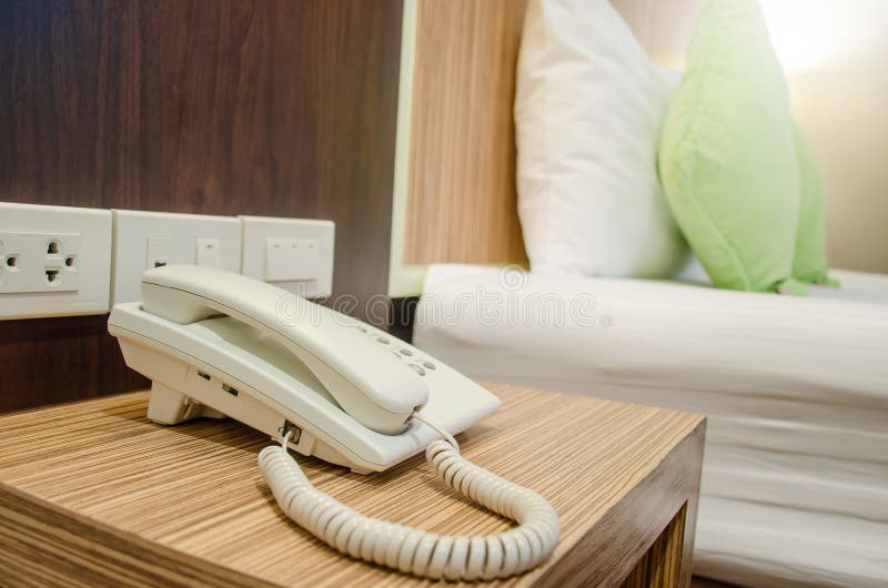 White Telephone on Desk Near a Bed in Hotel Stock Photo Image of