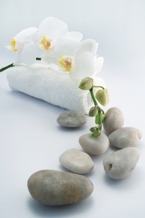 White towel and stones with orchid