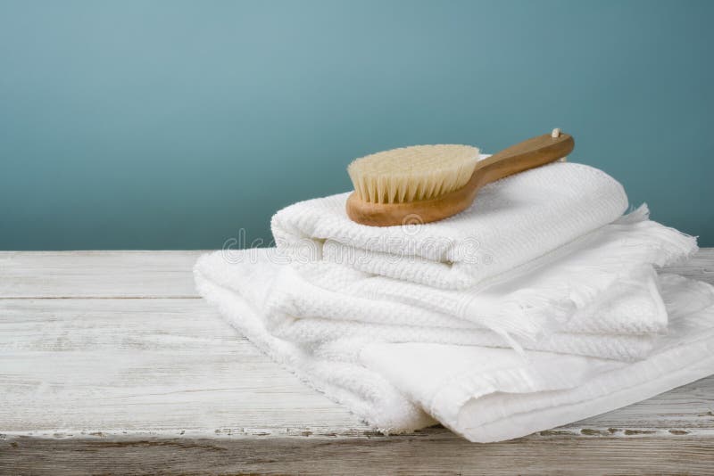 White towels and bath brush on wood over blue background stock images White towels and bath brush on wood over blue background stock images