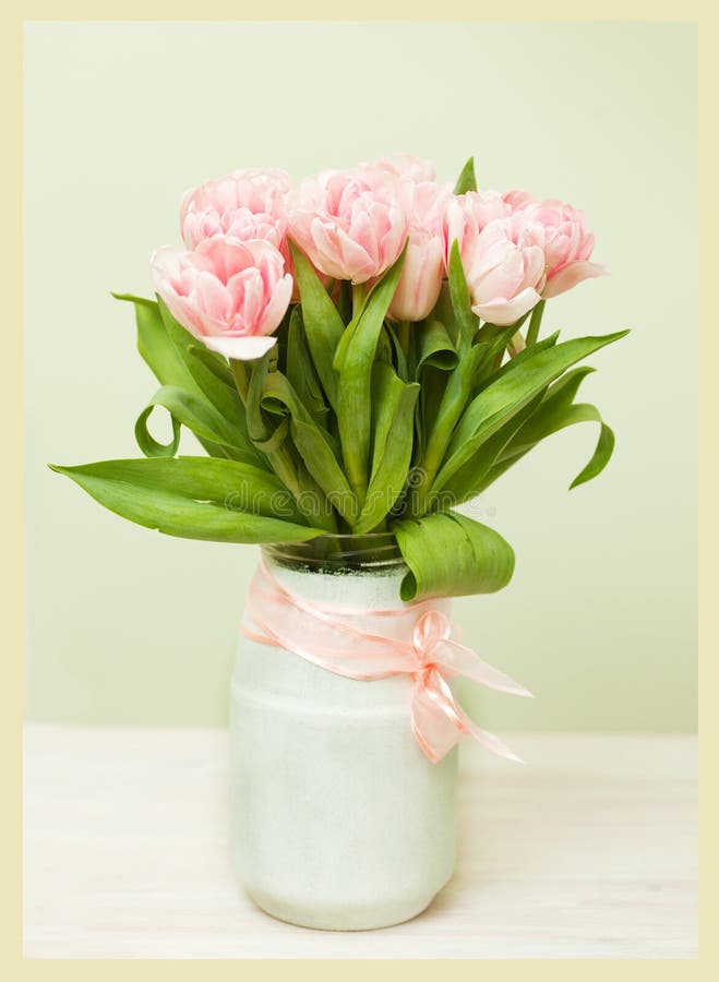 White vase with a bouquet of pink tulips