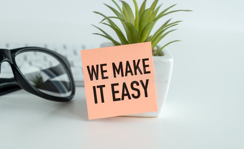A white vase with a plant in it and a piece of paper that says We Make it Easy royalty free stock photos