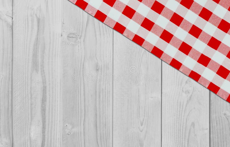 White vintage wooden table with red checker napkin. Checkered fabric and wooden light background. Decoration kitchen towel. Table