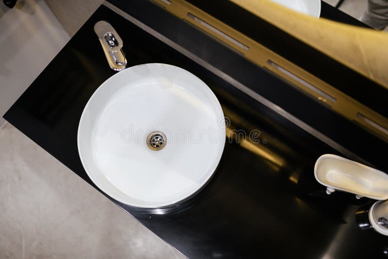 White Water Sink on Black Countertop in Bathroom. Top View Stock Photo