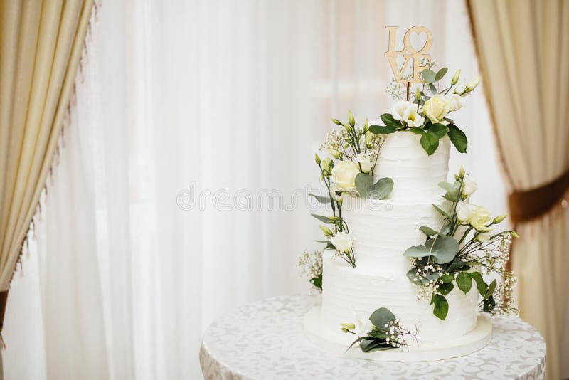White wedding cake with flowers. The word Love with heart. royalty free stock photos White wedding cake with flowers. The word Love with heart. royalty free stock photos