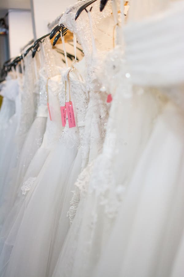 White Wedding Dresses Hanging on Racks Stock Photo - Image of ...