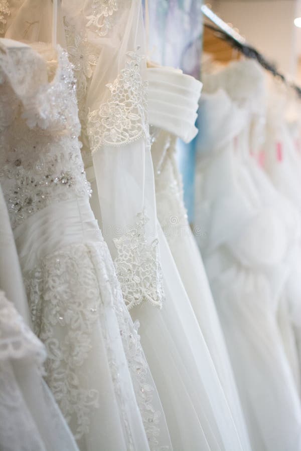 White Wedding Dresses Hanging on Racks Stock Photo - Image of clothing ...