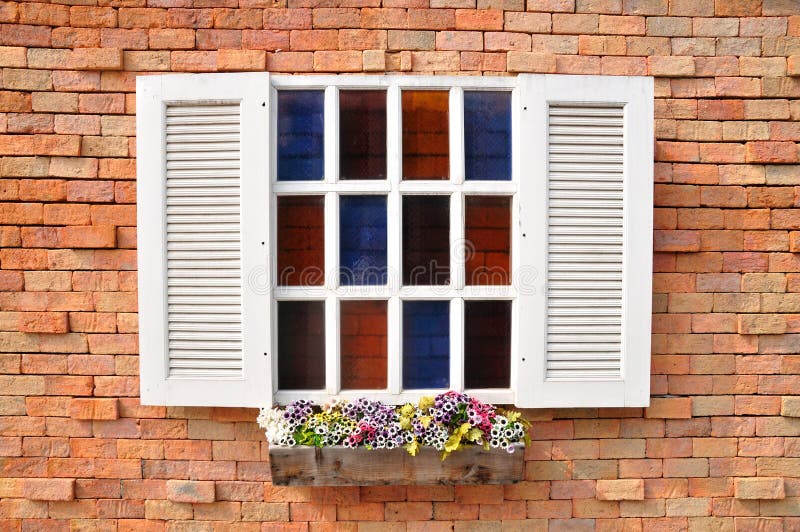 White window on red brick wall and color glass hang flowers pot