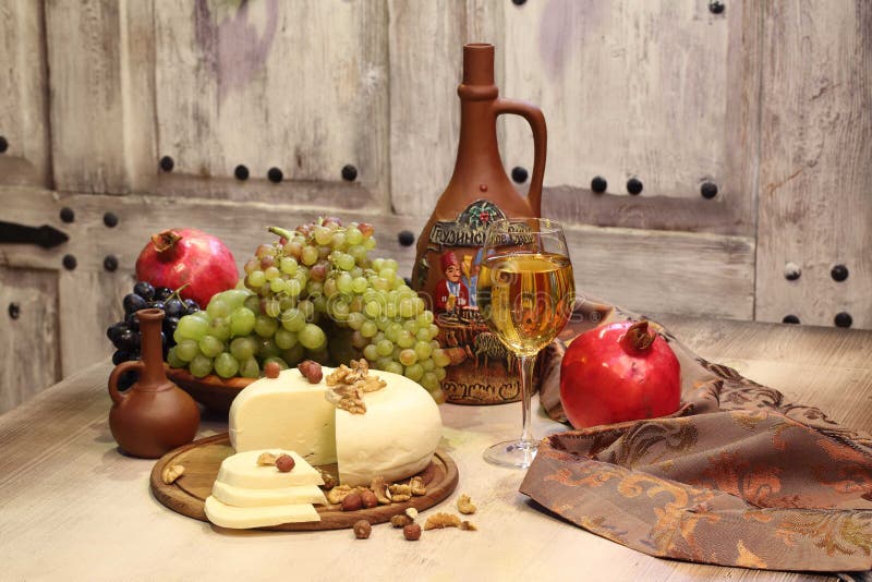 White wine, cheese, nuts, grapes and pomegranate