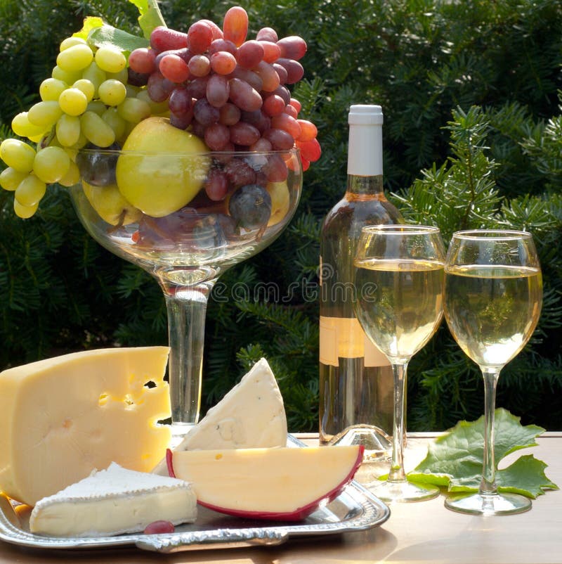 Two glasses of white wine, cheese varieties and fruit. Fruit scene stock images, royalty-free photos and pictures