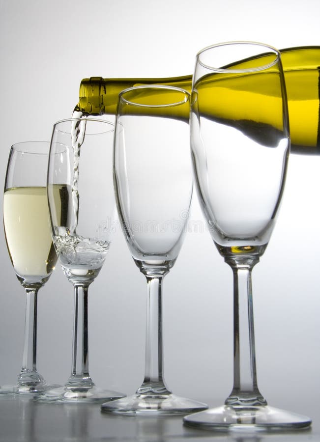 White wine pouring from bottle into wineglass