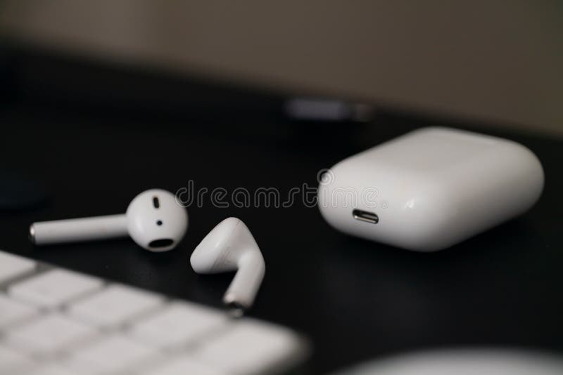 White wireless headphones on a black background. Air Pods with Wireless Charging Case
