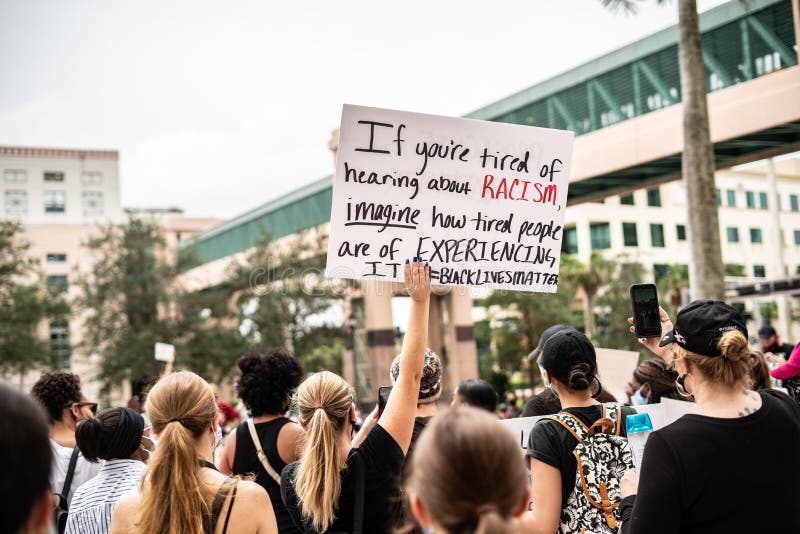 Black lives matter protester holds a sign above crowd