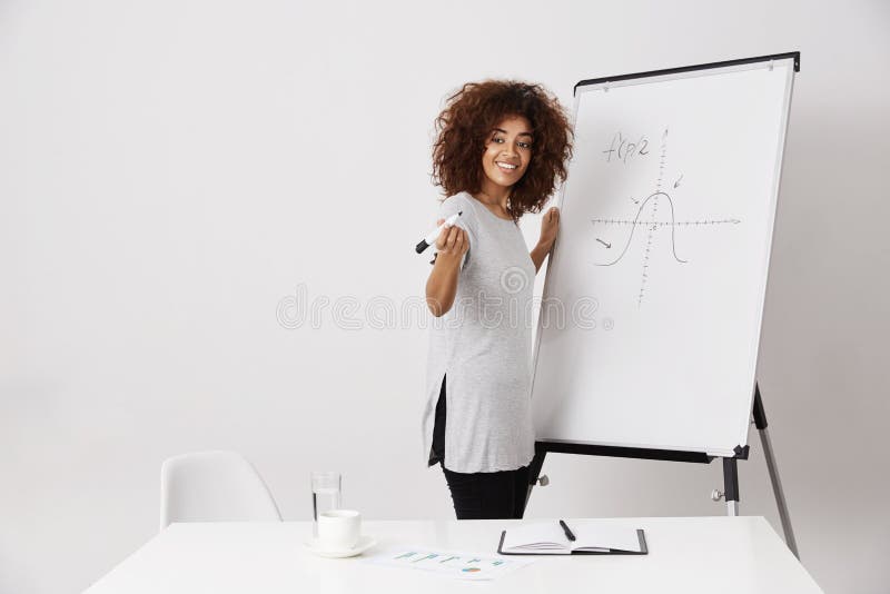 Whiteboard отметки африканской девушки усмехаясь стоящее близко над белой предпосылкой стоковые фото Whiteboard отметки африканской девушки усмехаясь стоящее близко над белой предпосылкой стоковые фото