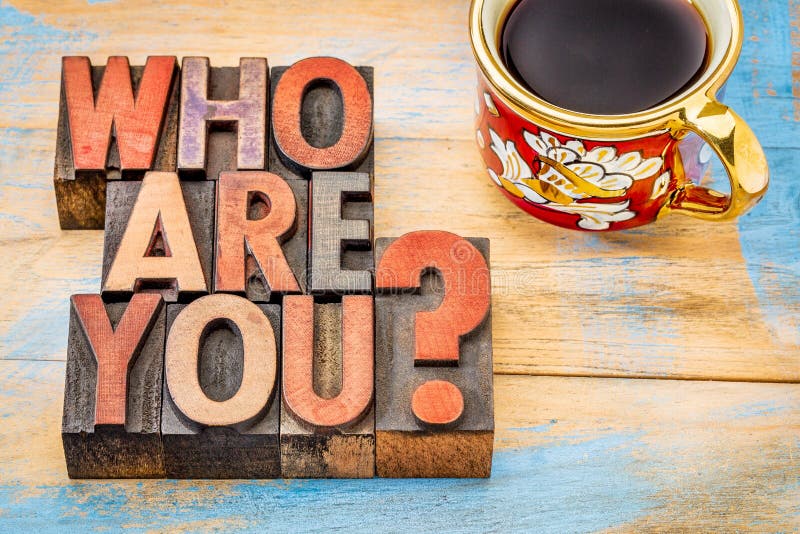 Who are you question - word abstract in letterpress wood type blocks against grunge painted wood with a cup of coffee. Who are you question - word abstract in letterpress wood type blocks against grunge painted wood with a cup of coffee