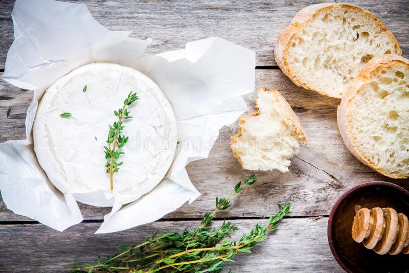 Whole Camembert Cheese with Thyme, Honey and Baguette Stock Image ...