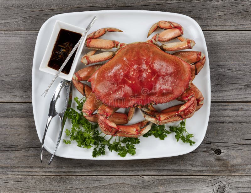 Whole Dungeness Crab In Dinner Setting On Wooden Table In Top View