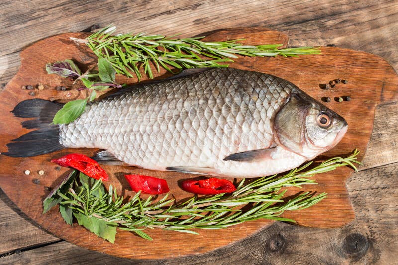 Whole Fresh Fish with Herbs and Lemon before Cooking Stock Photo