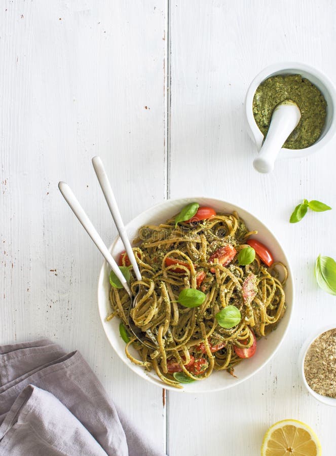 Whole Grain Pasta with Self Made Vegan Pesto and Tomatoes. White Wooden Background Stock Photo