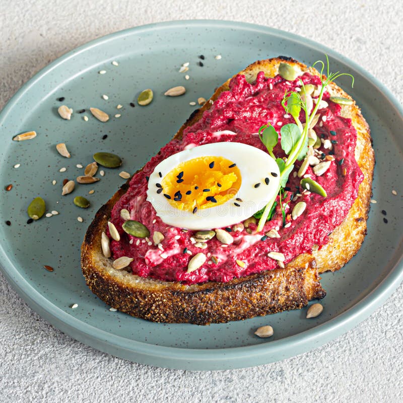 Whole Grain Toast with Beetroot Hummus, Seeds, Egg and Microgreens