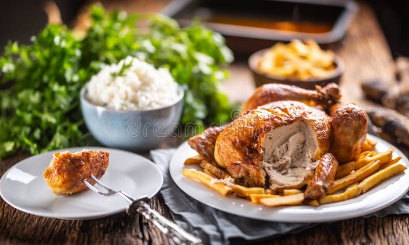 Whole Roasted Chicken Cut on a Fork with Side Dishes Rice and French