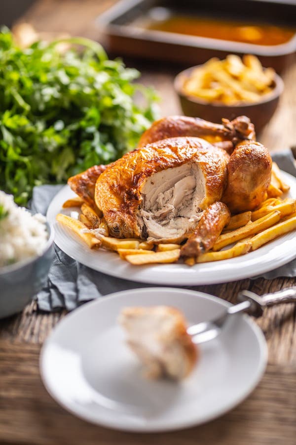 Whole Roasted Chicken Cut on a Fork with Side Dishes Rice and French