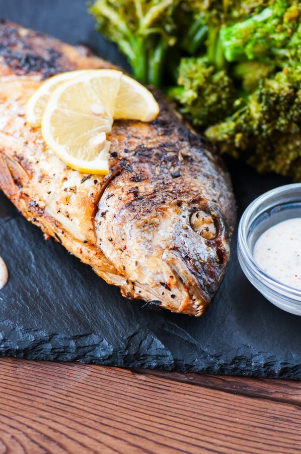 Whole Roasted Dorado Fish with Broccoli and Sauce Stock Photo Image