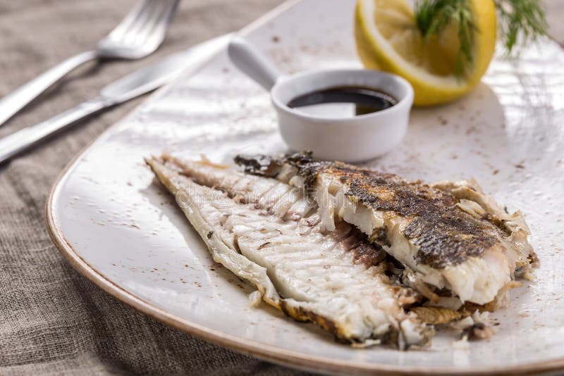 Whole Trout Fish Grilled with Lemon and Soy Sauce on the Table Stock