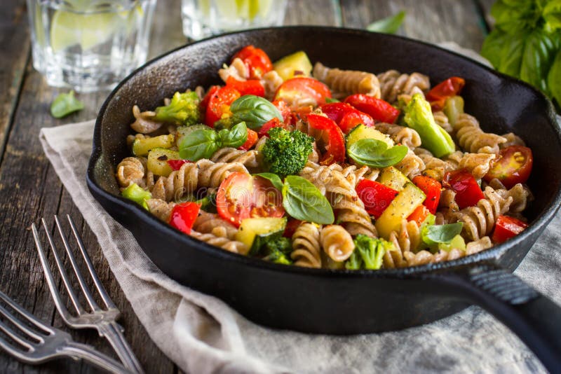 Vollkorn-pasta mit Gemüse auf gusseisernen Pfanne.
