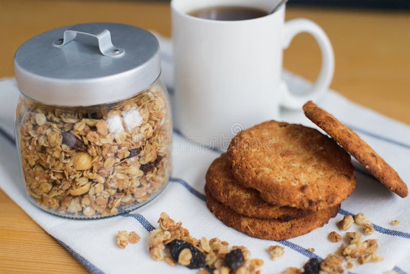 Wholemeal bunt för havremjölkakor med granola och kaffe på servett royaltyfri bild Wholemeal bunt för havremjölkakor med granola och kaffe på servett royaltyfri bild