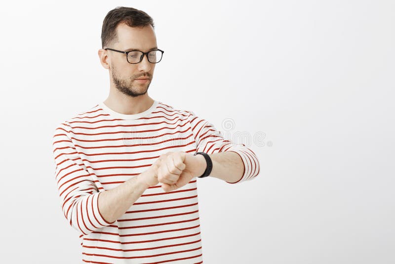 Wiast-up strzał ruchliwie skupiający się biznesmen w szkłach, patrzejący cyfrowych zegarki, sprawdza czas podczas gdy czekający fotografia stock Wiast-up strzał ruchliwie skupiający się biznesmen w szkłach, patrzejący cyfrowych zegarki, sprawdza czas podczas gdy czekający fotografia stock