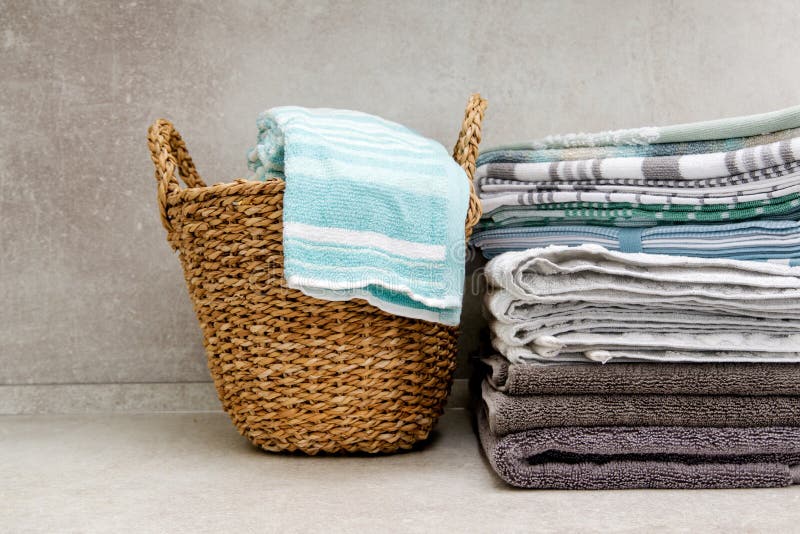 Wicker Basket with Clean Towels and Stack of Kitchen Towels on the