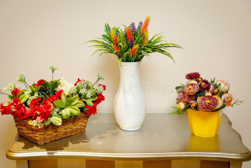 Wicker basket with decorative flowers. White vase with wildflowers. Yellow pot with flowers on the table. royalty free stock photo Wicker basket with decorative flowers. White vase with wildflowers. Yellow pot with flowers on the table. royalty free stock photo