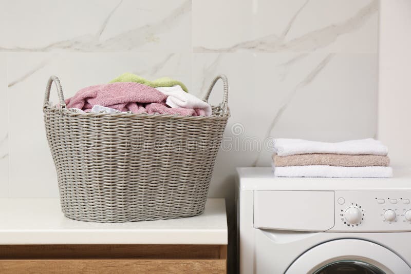 Wicker Basket with Dirty Laundry on Counter in Bathroom Stock Photo